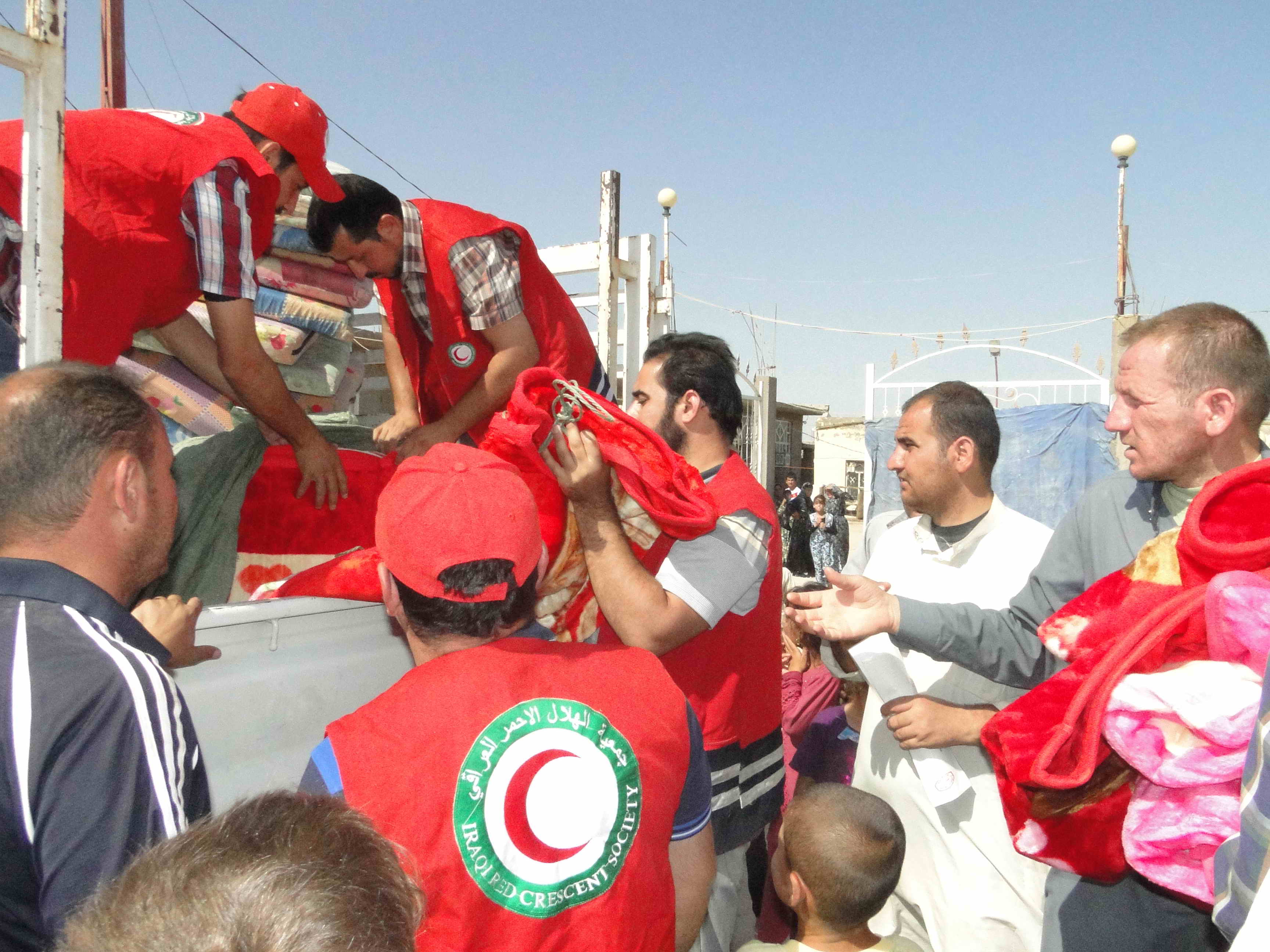 فرق الهلال الاحمر اثناء توزيع المساعدات الاغاثية